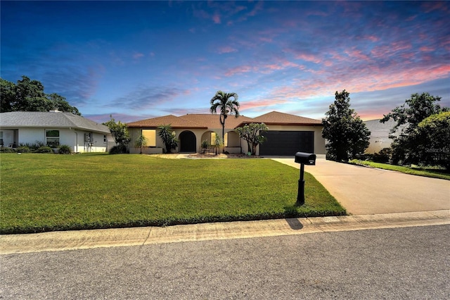 ranch-style house featuring a yard and a garage