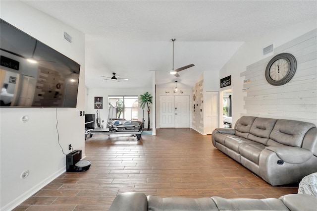 living room featuring lofted ceiling, ceiling fan, hardwood / wood-style floors, and a textured ceiling