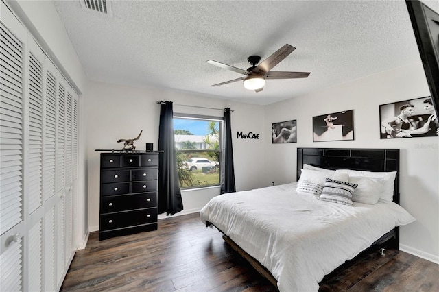 bedroom featuring a textured ceiling, ceiling fan, dark wood-type flooring, and a closet