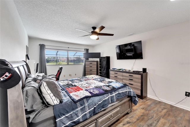 bedroom featuring ceiling fan, a textured ceiling, and dark hardwood / wood-style floors