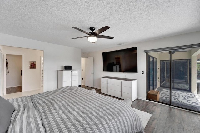 bedroom featuring ceiling fan, access to exterior, hardwood / wood-style floors, and a textured ceiling