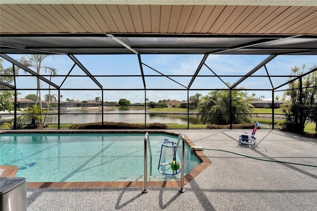 view of pool with a patio, glass enclosure, and a water view