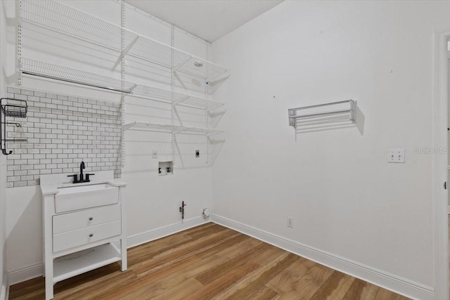 laundry room with gas dryer hookup, hardwood / wood-style floors, washer hookup, and sink