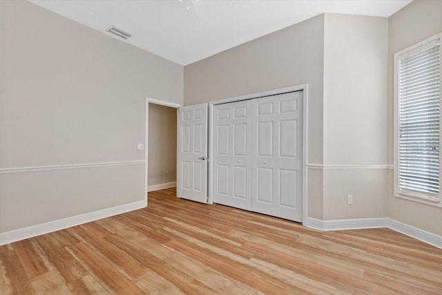 unfurnished bedroom with a closet and light hardwood / wood-style floors