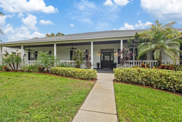 view of front facade with ceiling fan, a porch, and a front lawn