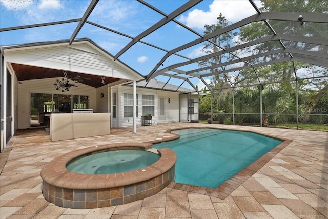 view of swimming pool featuring ceiling fan, an in ground hot tub, and glass enclosure