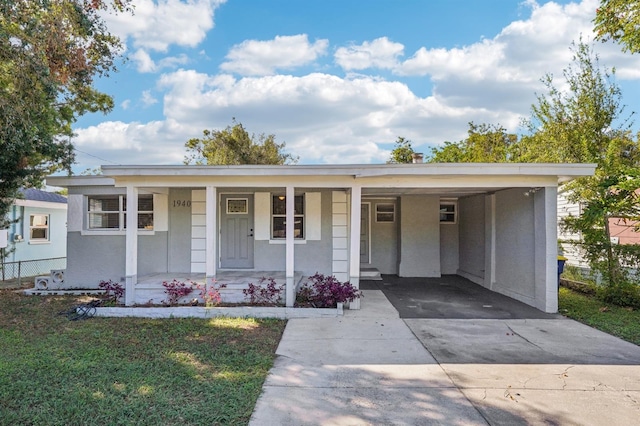 view of front facade featuring a carport, covered porch, and a front lawn