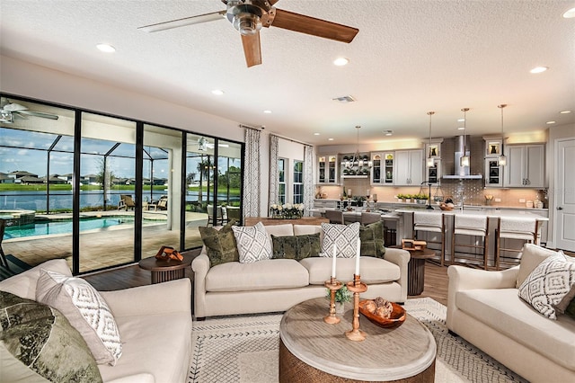 living room featuring hardwood / wood-style floors, a textured ceiling, and ceiling fan