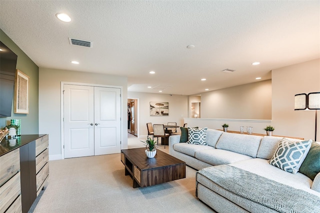 living room featuring light carpet and a textured ceiling