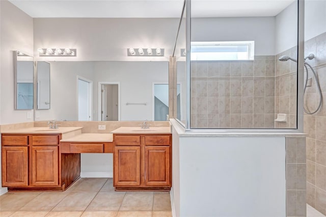 bathroom with a tile shower, tile patterned flooring, and vanity