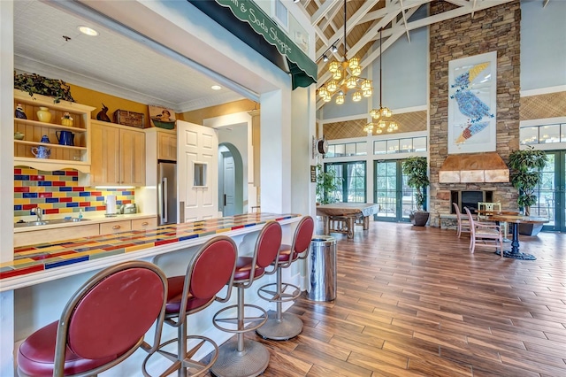 kitchen with a healthy amount of sunlight, a fireplace, an inviting chandelier, and pendant lighting