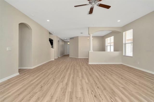 spare room with light hardwood / wood-style floors, ceiling fan, and ornate columns