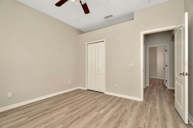 unfurnished bedroom featuring light hardwood / wood-style floors, a closet, and ceiling fan