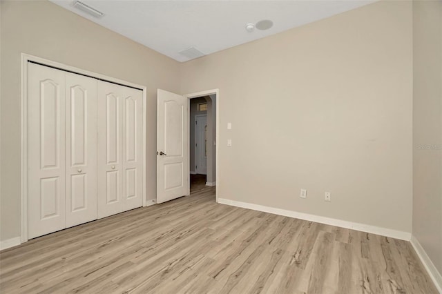 unfurnished bedroom with a closet and light hardwood / wood-style flooring