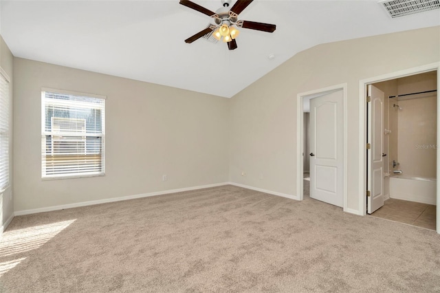 unfurnished bedroom with light carpet, vaulted ceiling, ceiling fan, and ensuite bathroom