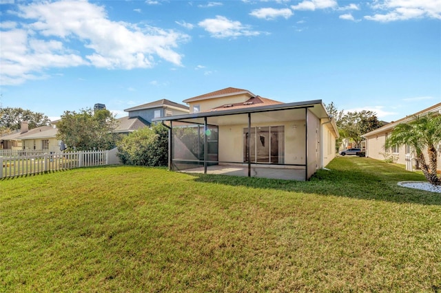 back of house with a patio, a sunroom, and a lawn