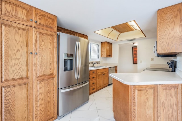 kitchen featuring kitchen peninsula, sink, and appliances with stainless steel finishes