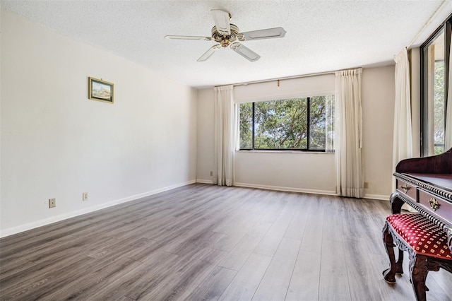 interior space with a wealth of natural light, ceiling fan, and light wood-type flooring