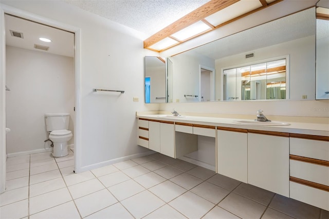 bathroom featuring tile patterned flooring, toilet, a textured ceiling, and vanity