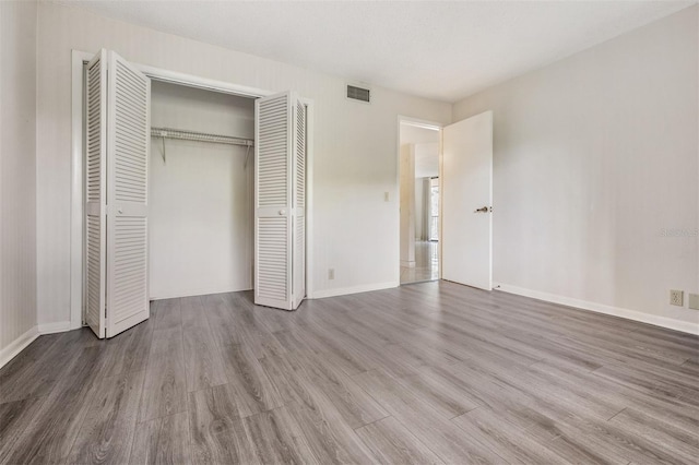 unfurnished bedroom featuring a closet and hardwood / wood-style flooring