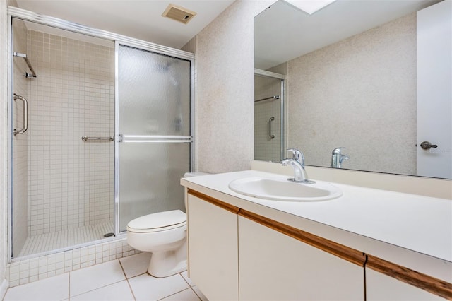 bathroom with vanity, toilet, an enclosed shower, and tile patterned floors