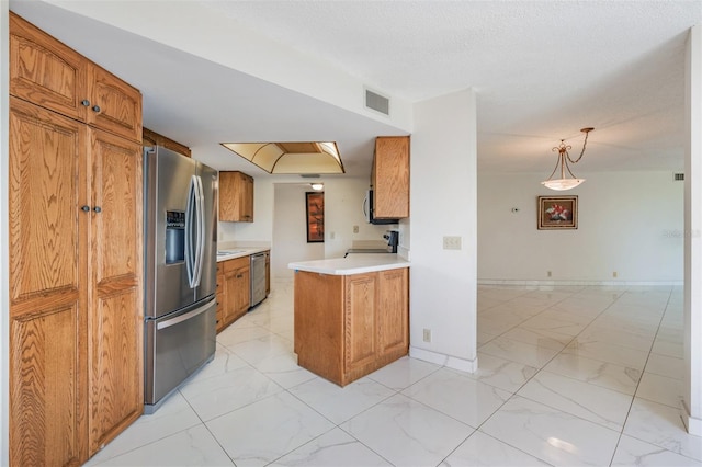 kitchen featuring a textured ceiling, stainless steel appliances, decorative light fixtures, and kitchen peninsula