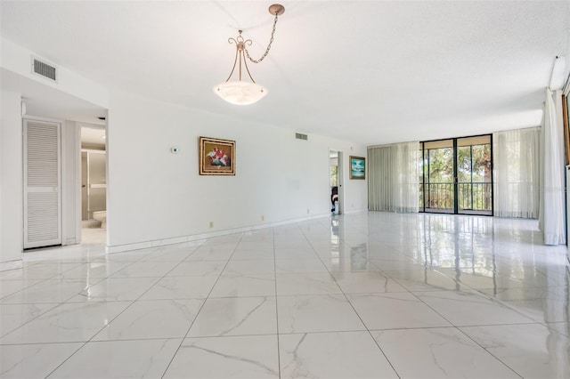 unfurnished room featuring a wall of windows