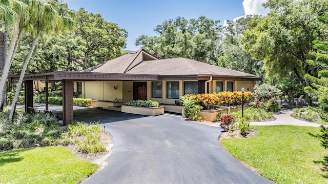 view of front of property featuring a front lawn and a carport