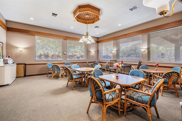 carpeted dining area with washer / clothes dryer and a textured ceiling