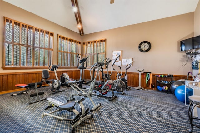 interior space featuring lofted ceiling, wood walls, and carpet flooring