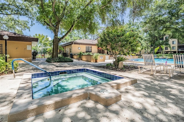 view of pool with a community hot tub and a patio