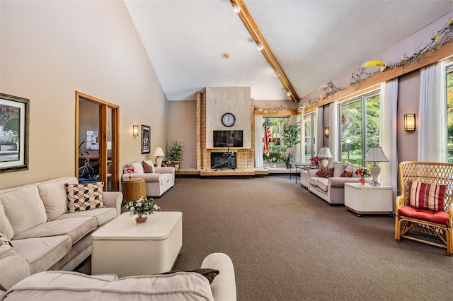 carpeted living room with rail lighting, high vaulted ceiling, a brick fireplace, and beam ceiling