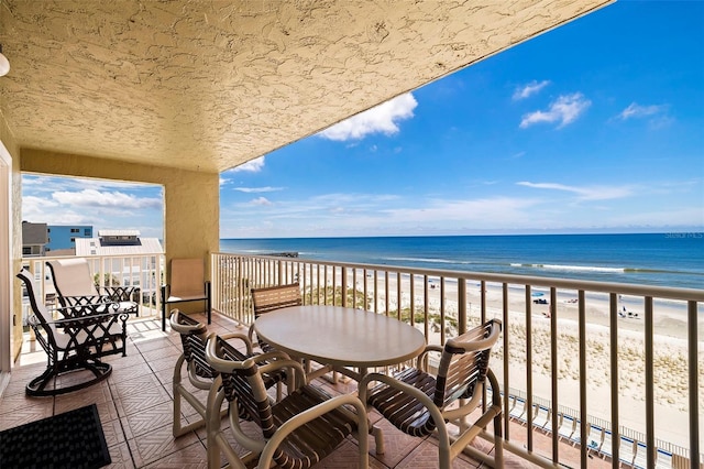 balcony featuring a beach view and a water view