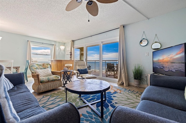 living room with a textured ceiling, plenty of natural light, and ceiling fan