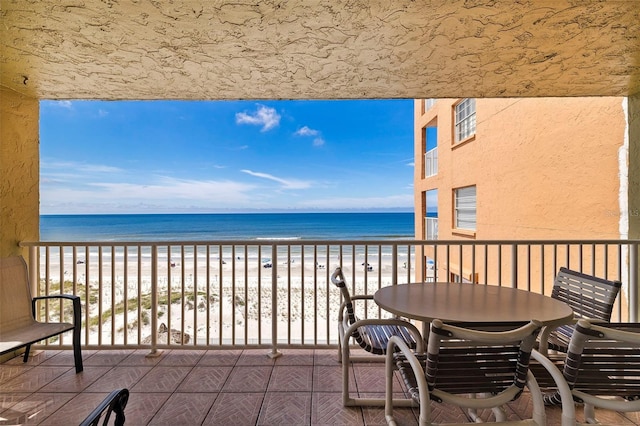 balcony with a water view and a beach view