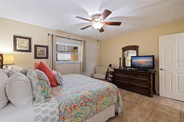 bedroom featuring ceiling fan, light tile patterned flooring, and a textured ceiling