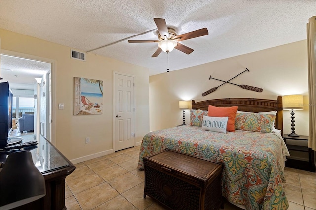 bedroom with a textured ceiling, light tile patterned floors, and ceiling fan