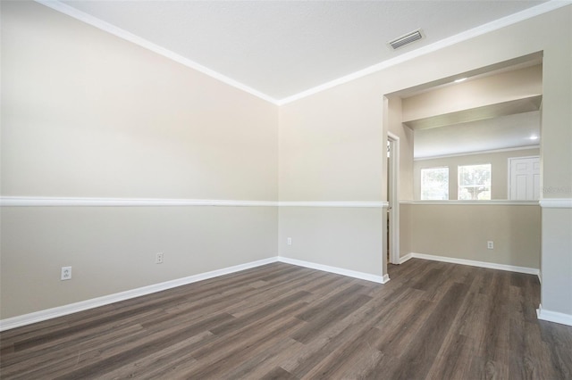 spare room with ornamental molding and dark hardwood / wood-style flooring