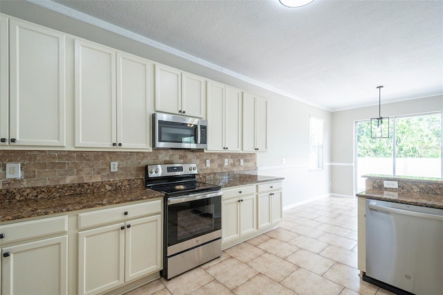 kitchen with pendant lighting, stainless steel appliances, dark stone countertops, and light tile patterned floors