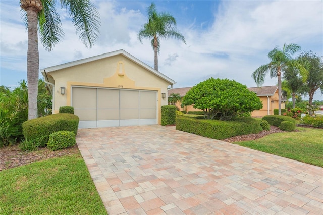 single story home featuring a front yard and a garage