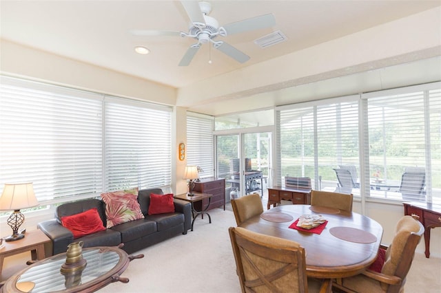 carpeted dining room with ceiling fan