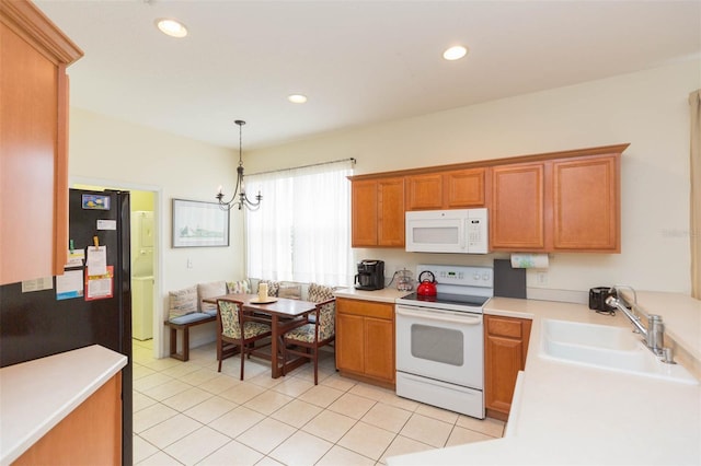 kitchen with white appliances, light tile patterned floors, an inviting chandelier, decorative light fixtures, and sink