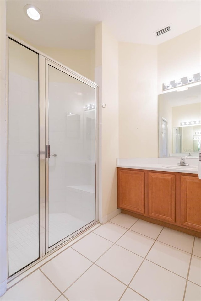 bathroom featuring walk in shower, vanity, and tile patterned flooring