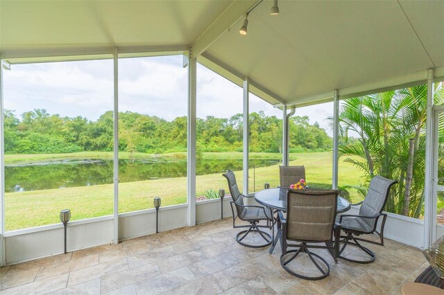 sunroom / solarium with vaulted ceiling, a water view, and rail lighting