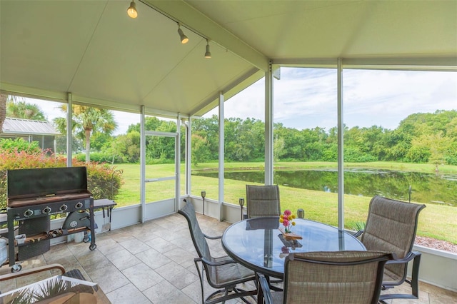 sunroom with lofted ceiling with beams and a water view