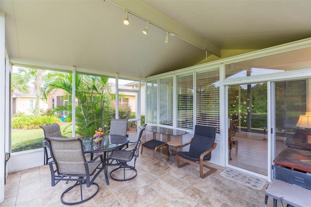 sunroom featuring lofted ceiling with beams and rail lighting