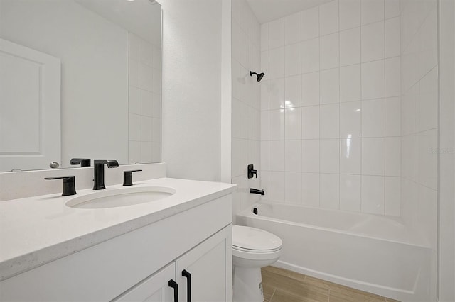 full bathroom featuring vanity, tiled shower / bath combo, and toilet