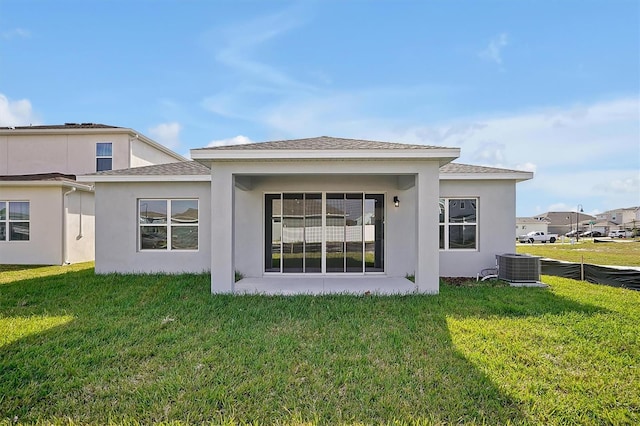 back of property featuring a lawn and central AC unit