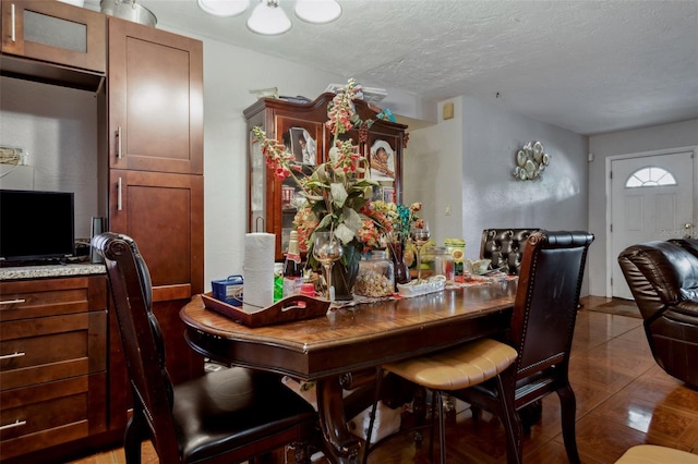 tiled dining space with a textured ceiling