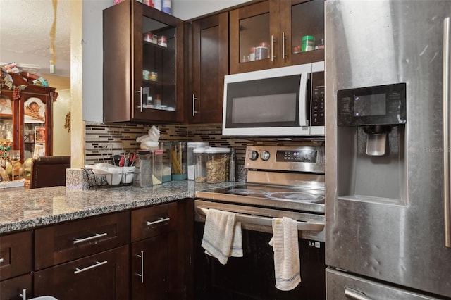 kitchen with light stone countertops, stainless steel appliances, decorative backsplash, and dark brown cabinetry